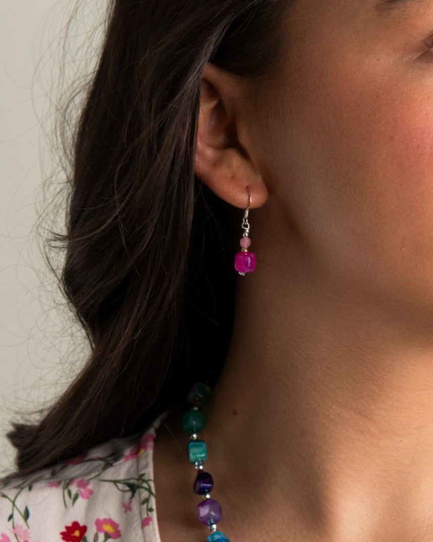 Woman wearing a colorful beaded necklace and earrings.