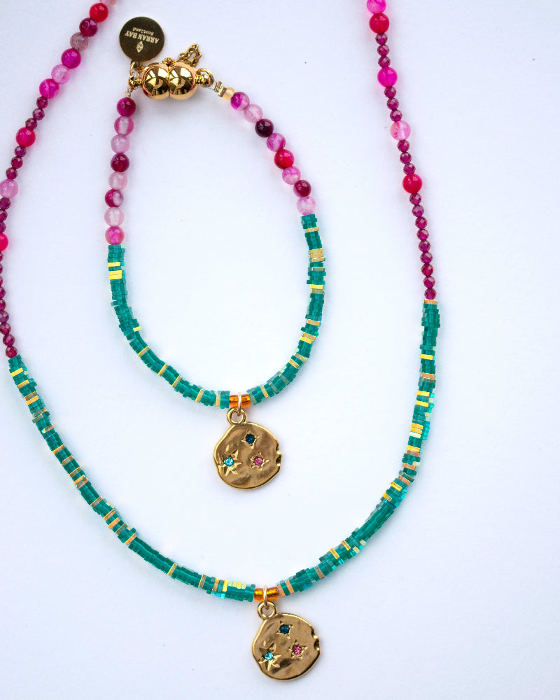 Two beaded necklaces with gold pendants pink and green