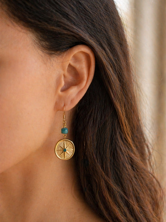Gold earring with turquoise stone worn by a person to show scale for estelle roe earring