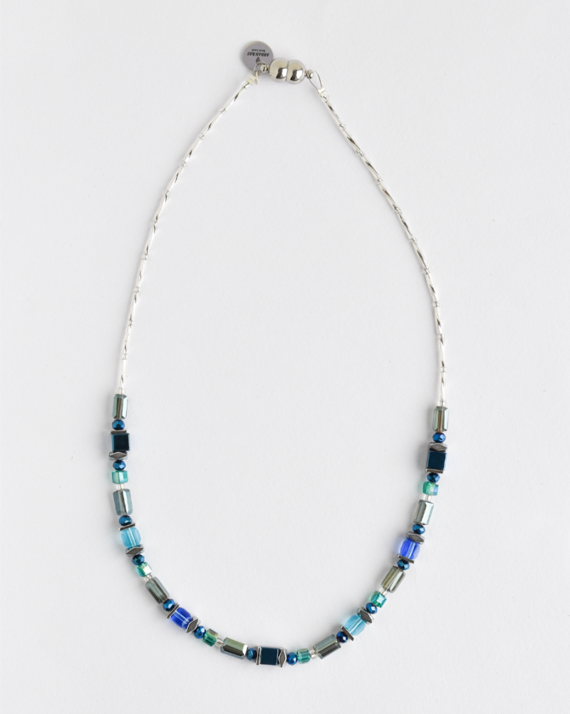 A metallic shimmering hematite necklace with translucent glass in blue and teal colors, hematite stones, and a stainless steel strong clasp.