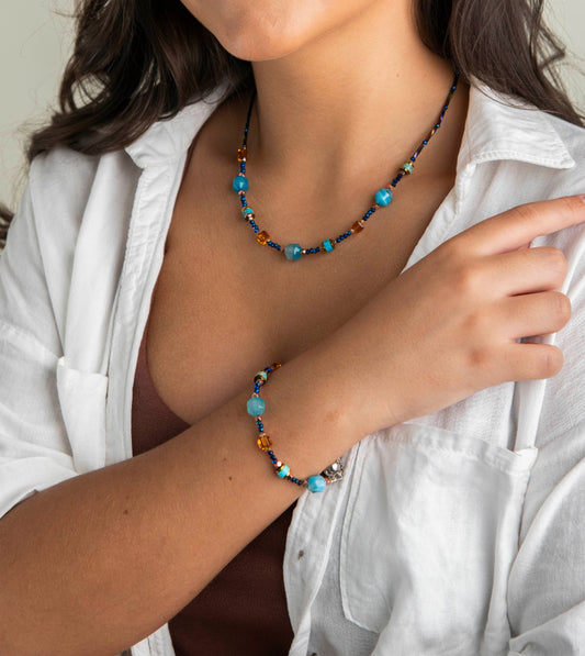 Person wearing a colorful beaded necklace and bracelet 