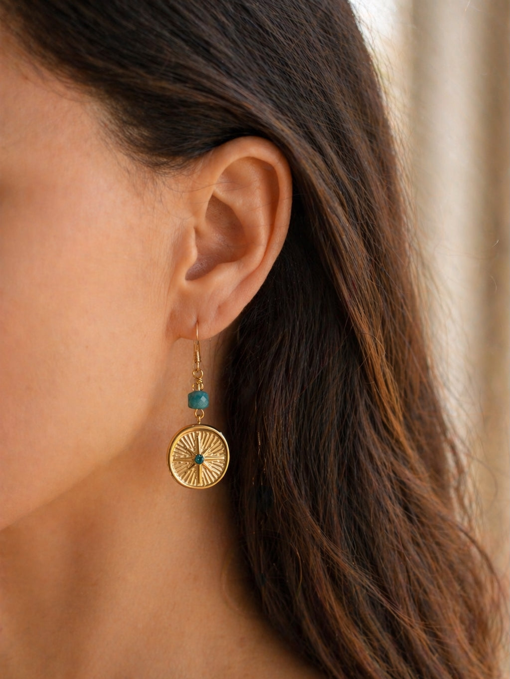 Gold earring with turquoise stone worn by a person to show scale for estelle roe earring