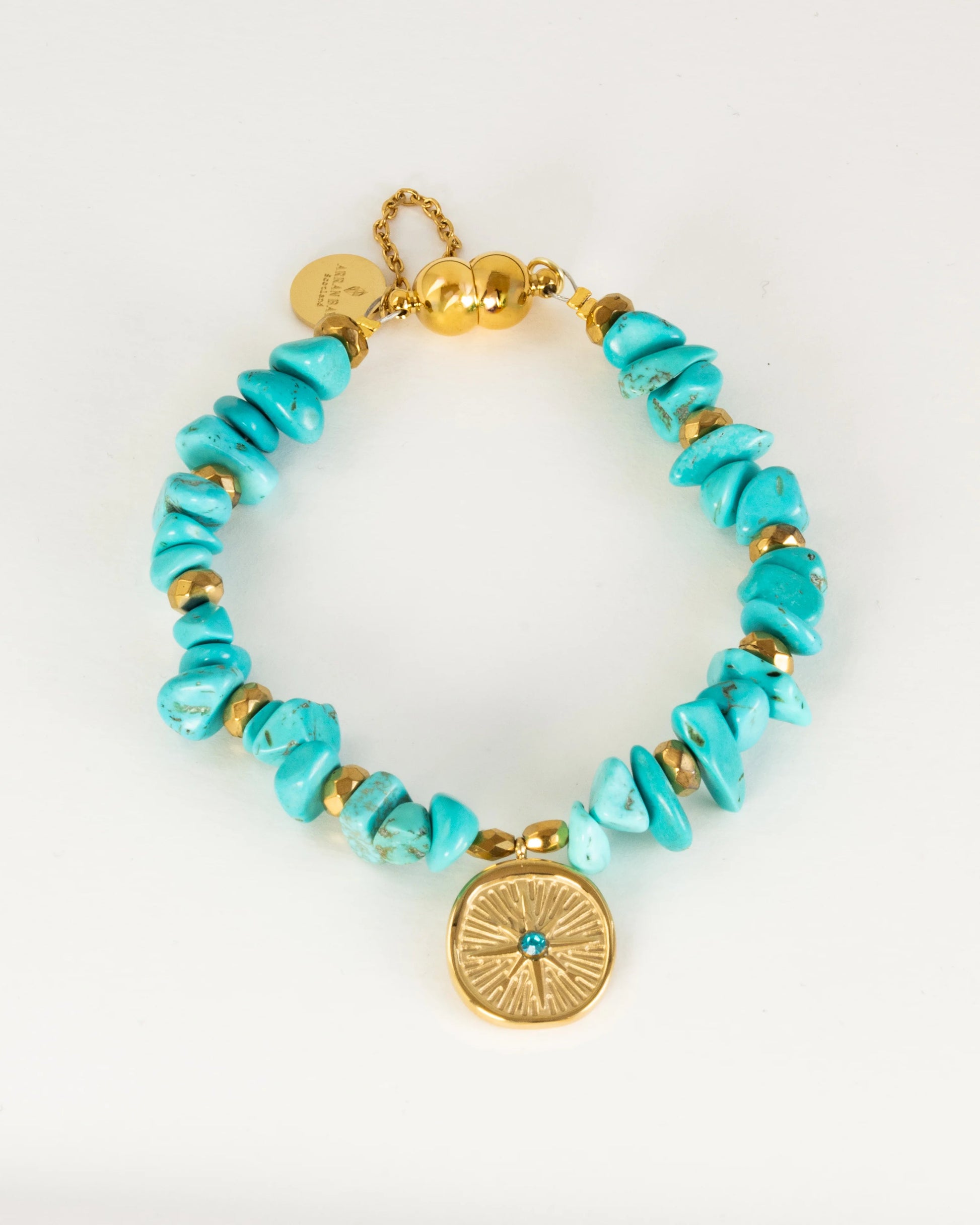 Turquoise beaded bracelet with gold accents on a white background